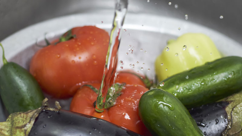 vegetables being rinsed with water